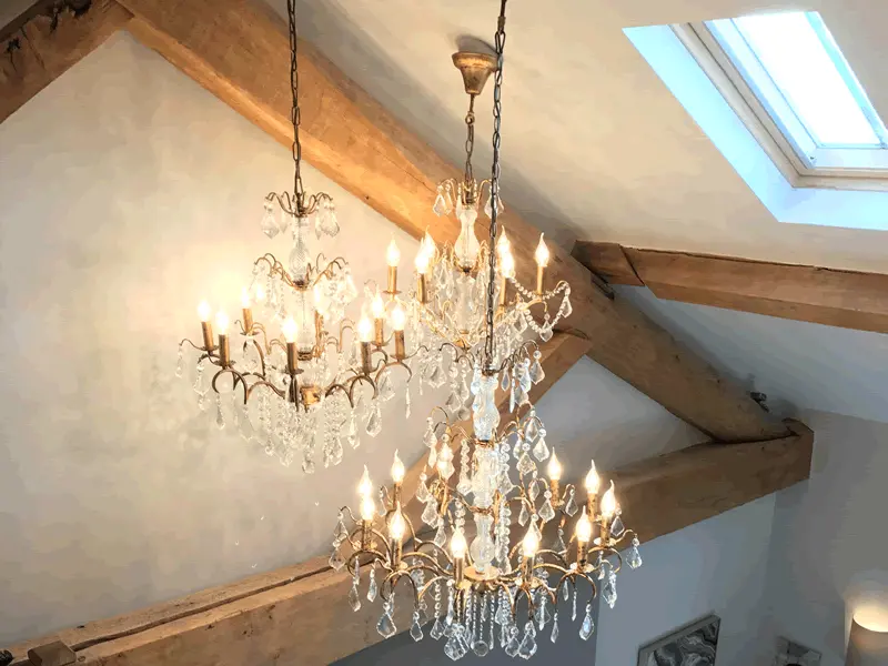 Crystal chandeliers hanging from a vaulted oak-beamed ceiling