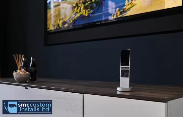 Control4 Neeo remote docked on media unit beneath wall-mounted TV