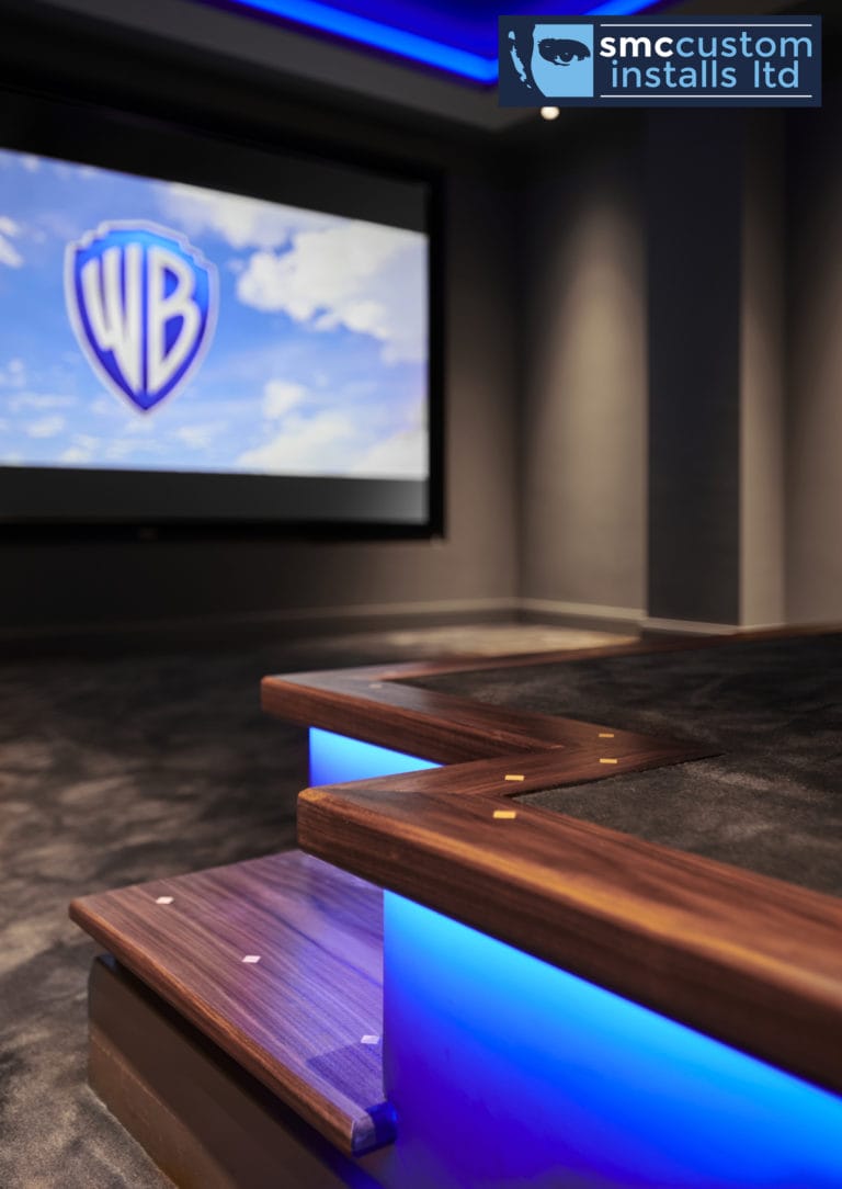 Walnut steps with blue LED strip lighting up to tiered seating, dedicated cinema room