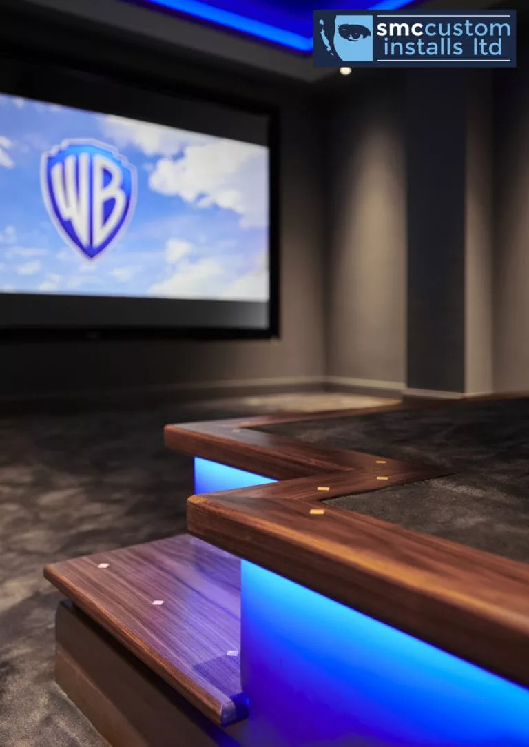 Walnut steps with blue LED strip lighting up to tiered seating, dedicated cinema room
