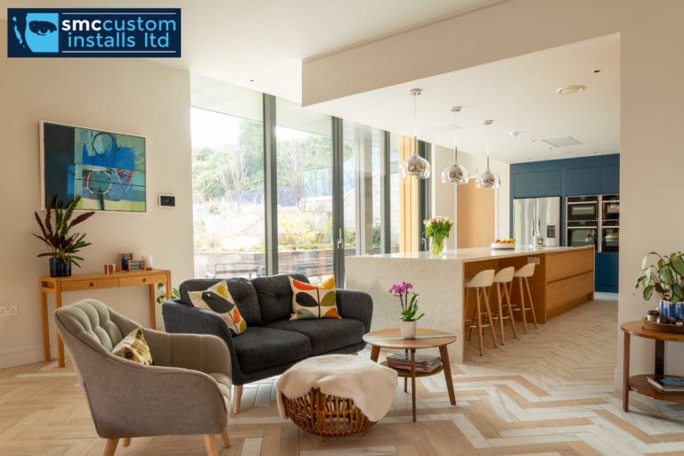 Open-plan living and kitchen area with pendant island lighting and feature artwork