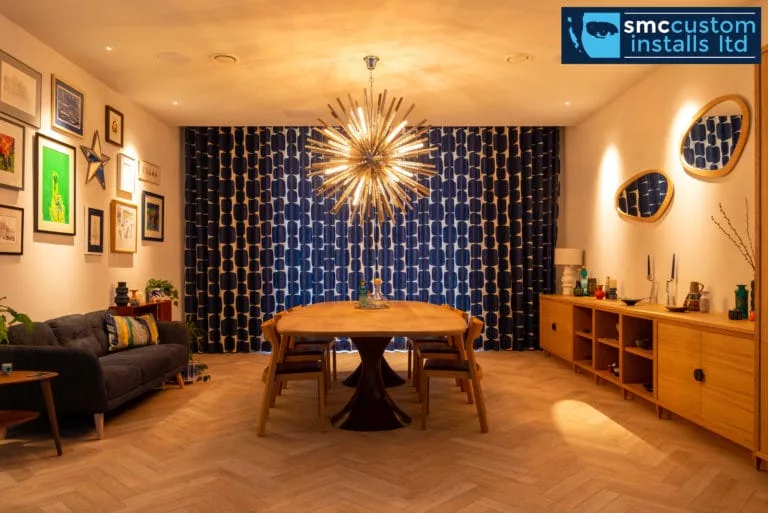 Dining room with statement chandelier, oak table and patterned feature wallpaper lighting scheme