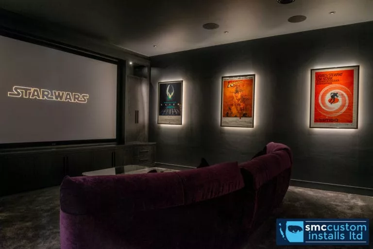Dedicated cinema room with velvet sofa, projection screen and backlit Star Wars posters