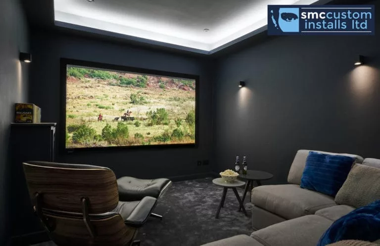 Dedicated home cinema room with projection screen, chaise longue and cove ceiling lighting