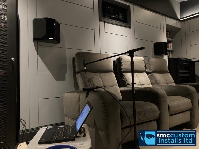 Measurement microphone and laptop calibrating surround sound speakers in a home cinema