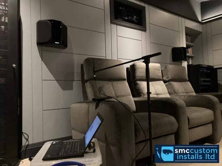 Measurement microphone and laptop calibrating surround sound speakers in a home cinema