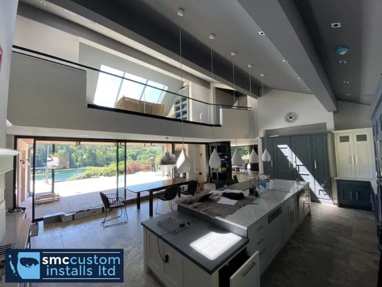Open-plan kitchen with vaulted ceiling, mezzanine landing and sliding doors to the terrace