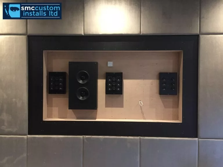 In-wall speaker and control keypads set into a media wall recess during fit-out