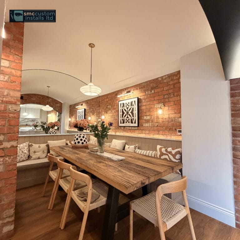 Exposed-brick dining room with bench seating, wall lights and pendant over rustic table