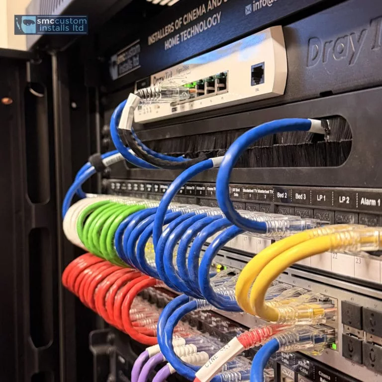 Colour-coded structured cabling patched into a network equipment rack with router and switches