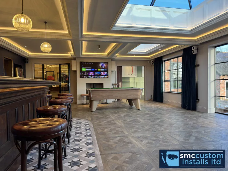 Games room with roof lantern, pool table and wall-mounted TV beside the bar