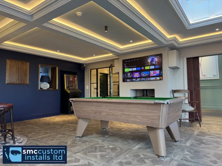 Pool table beneath a roof lantern with wall-mounted TV and LED coffered ceiling