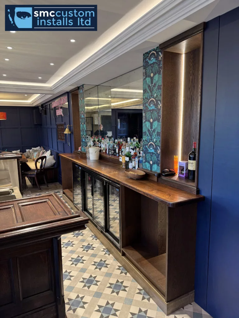Back bar with mirrored splashback, glass-fronted drinks fridges and illuminated shelving