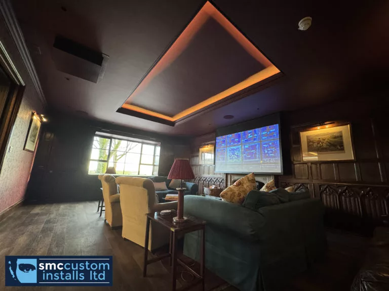 Rear view of the lounge cinema showing the projection screen and LED-lit coffered ceiling