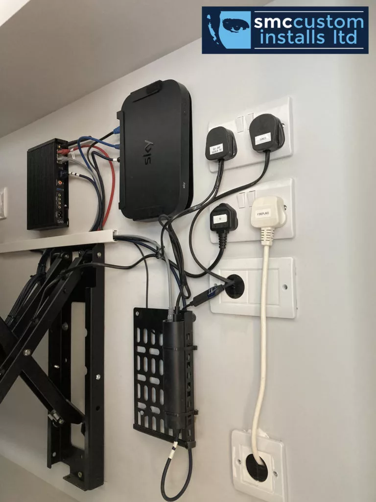 Concealed sockets, streaming devices and cable management basket behind an articulated TV wall bracket
