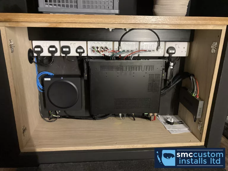 AV amplifier, subwoofer and connection modules concealed inside a joinery cabinet