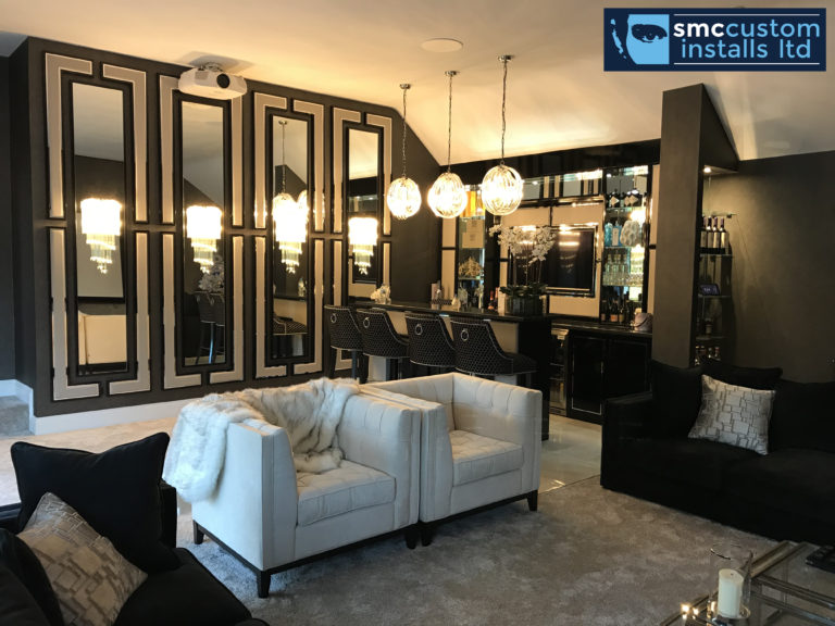 Bar lounge with mirrored panelling, glass pendant lights and white armchairs