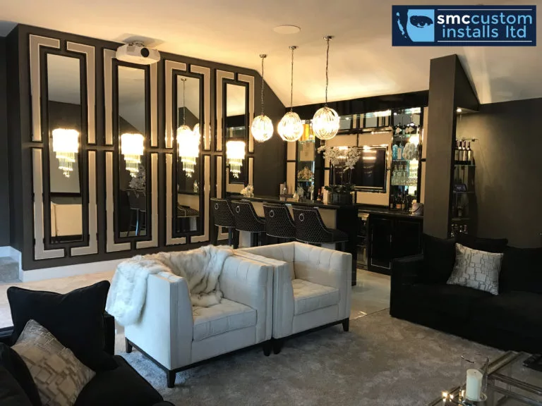 Bar lounge with mirrored panelling, glass pendant lights and white armchairs