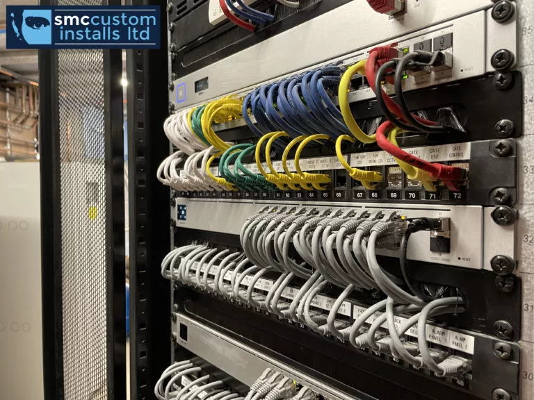 Equipment rack close-up showing patch panels, network switch and tidy structured cabling