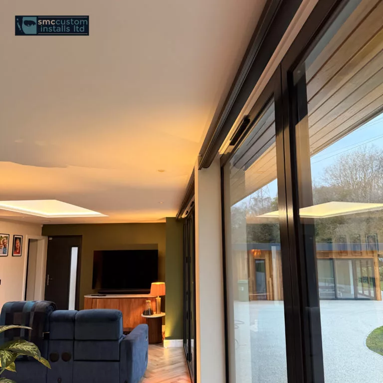 Garden room living space with wall-mounted TV, rooflight and full-height sliding glass doors