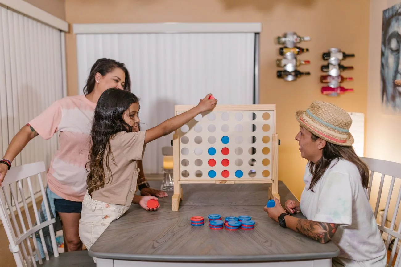 Family playing a giant four-in-a-row game at a dining table