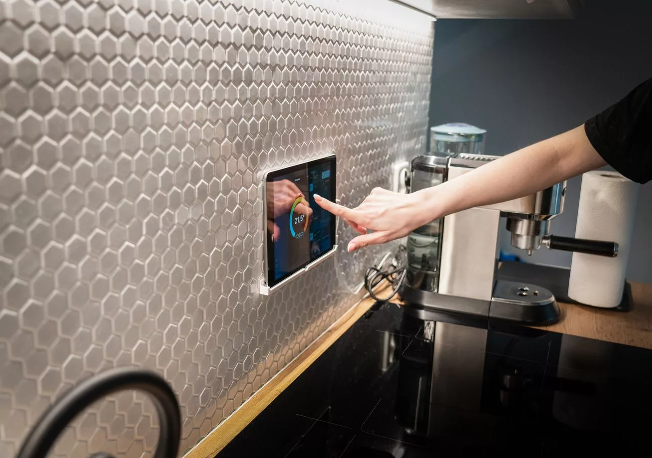 Wall-mounted smart home touchscreen controlling a kitchen