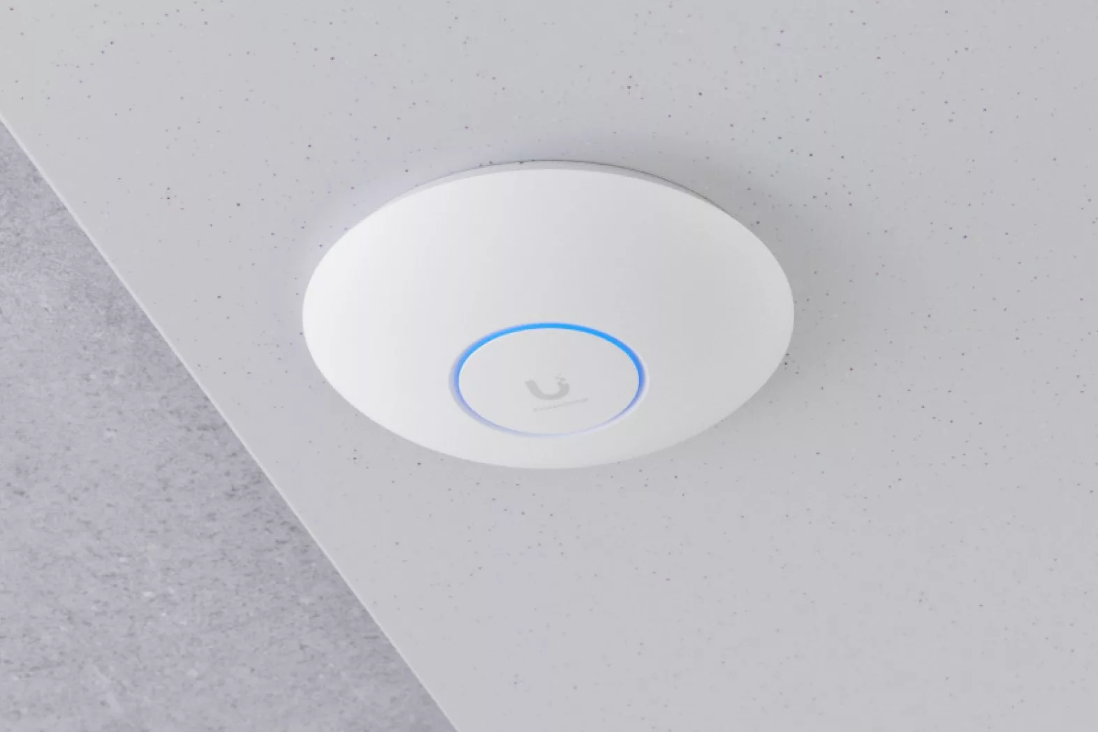 Ubiquiti WiFi 7 access point mounted on a plain white ceiling